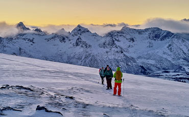 Dämmerungsstimmung mit Schneeschugeher am Polarkreis in Nordnorwegen