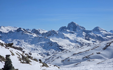 Blick auf die verschneiten Alpen bei Juf in Graubünden mit markanten Gipfeln unter klarem blauem Himmel.